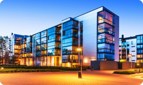 "Fachada moderna de edifício residencial de luxo ao entardecer, representando o crescimento do mercado de imóveis de alto padrão no Brasil."